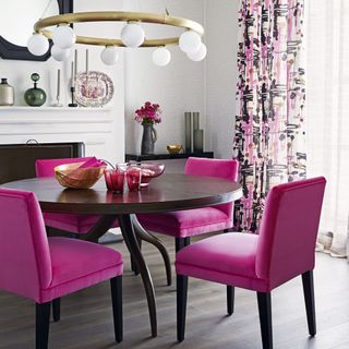 neutral dining room with bright pink chairs