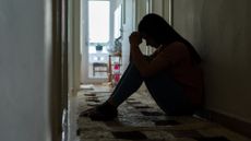 Sad woman sitting corridor floor