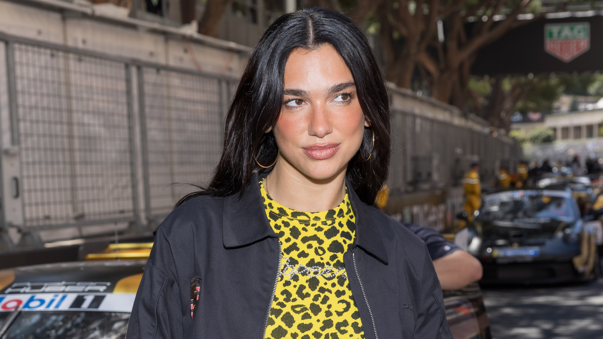 Dua Lipa attends the Monaco F1 Grand Prix wearing a yellow leopard print top from Coperni, the brand&#039;s boyfriend jean pants, and her Puma Speedcat OG sneakers