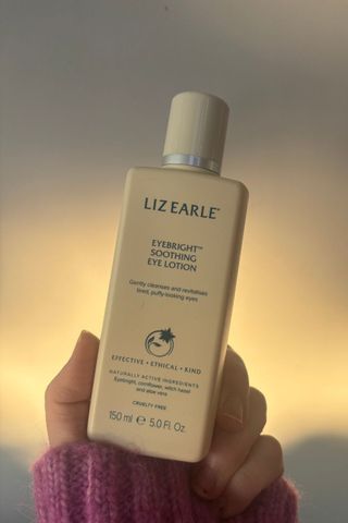 a hand holding liz earle soothing eye treatment