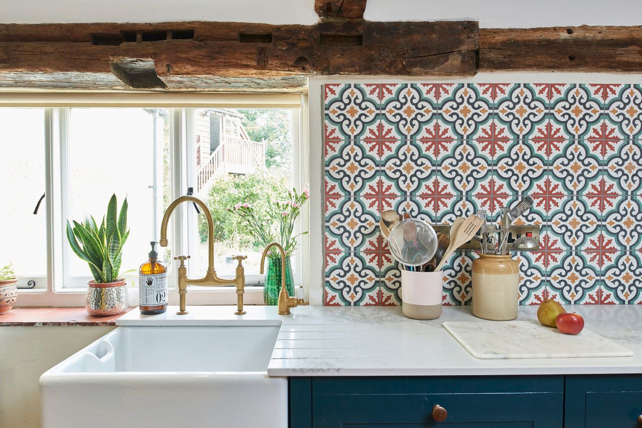 a colorful tiled splashback in country style home with butler&#039;s sink