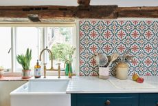 a colorful tiled splashback in country style home with butler's sink