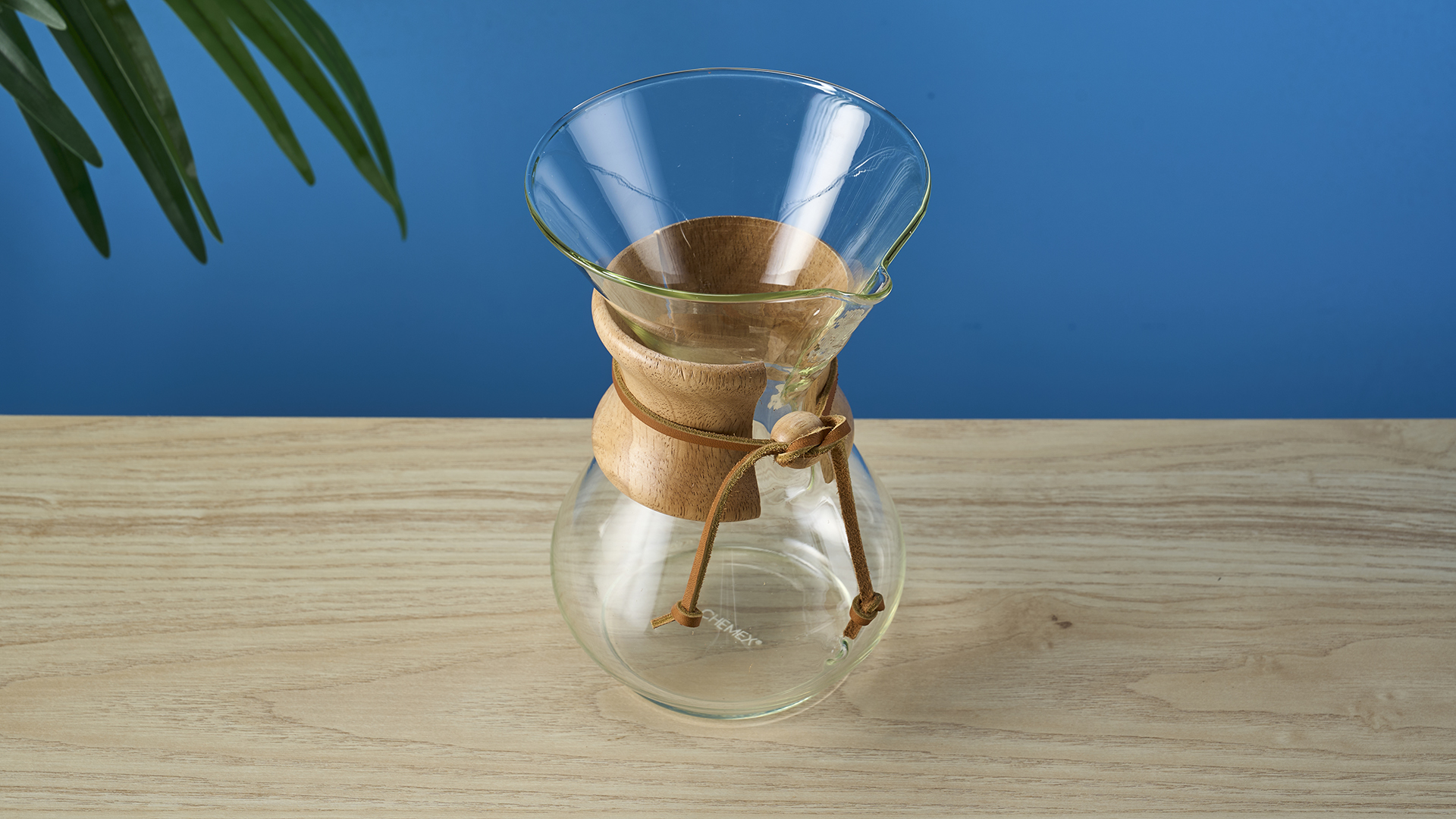 an hourglass coffee maker by Chemex with a 6 cup capacity and a wooden collar with a rawhide tie