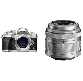 The Olympus OM-D E-M10 Mark IV camera next to a lens on a white background