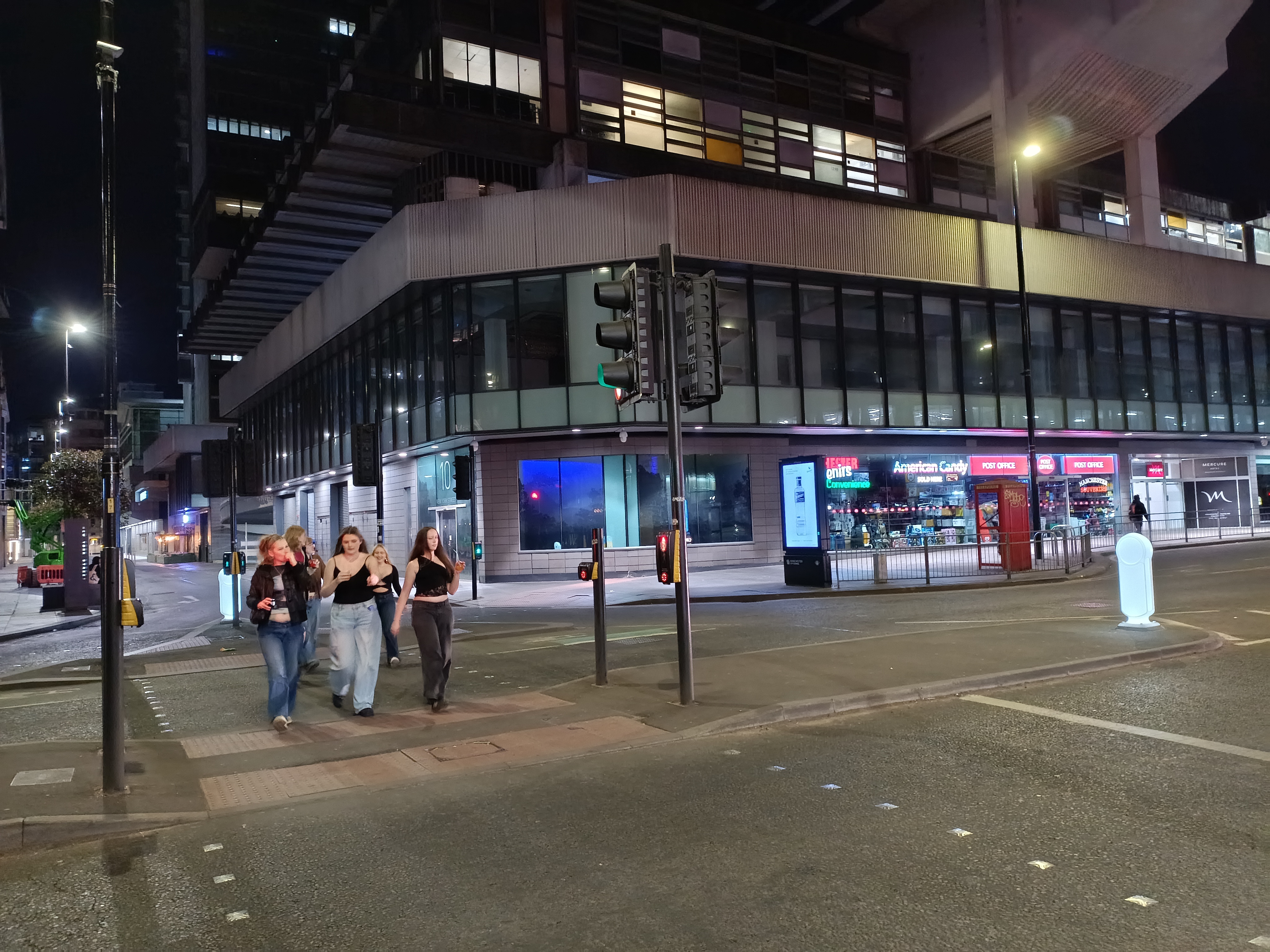 Several young women on a night out in Manchester cross the road
