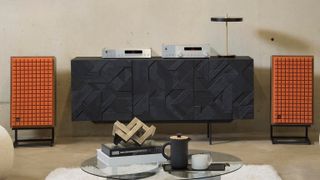 JBL L100 Classic MkII speakers with orange foam grille and hi-fi separates on cabinet