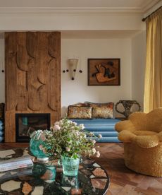 Living room with wooden floors and flower shaped yellow armchair and wooden fire surround