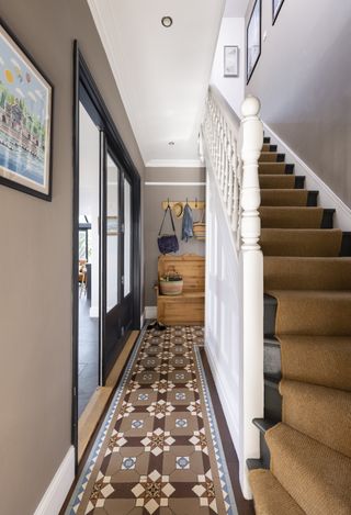 victorian tiles hallway with brown stair runner up stairs