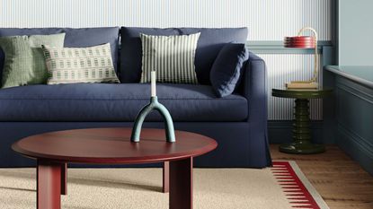 living room with navy blue couch and pale blue wallpaper