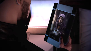 Shepard looks at a photo of Tali without her mask on in Mass Effect 3.