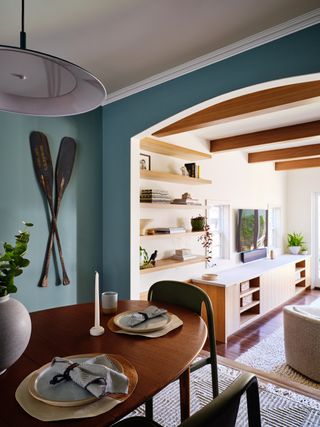 A subtley coastal light blue dining room with oars featured on the wall