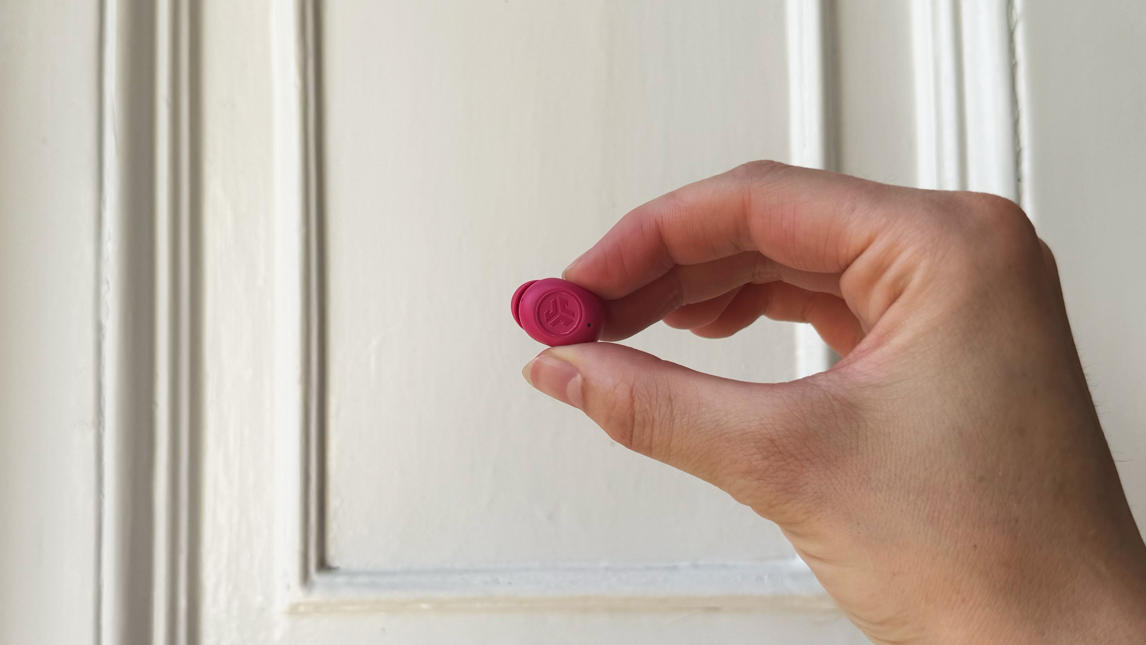 the jlab jbuds mini in hot pink against a white background