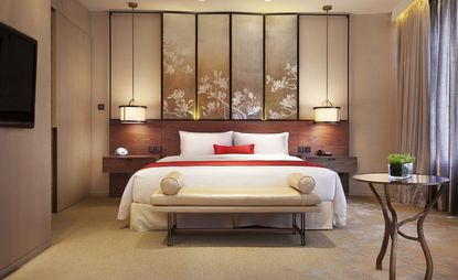 Hand-painted wallpaper and bed-head screens echo the leaves from plane trees