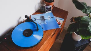 Nevermind album on a record player with a plant in the background