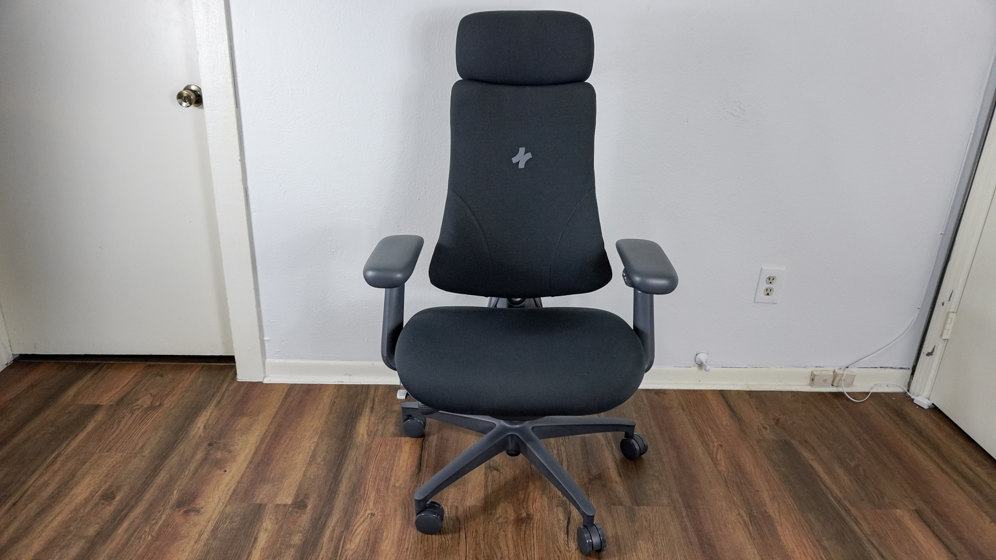 The LiberNovo Omni office chair seen from the front up against a wall