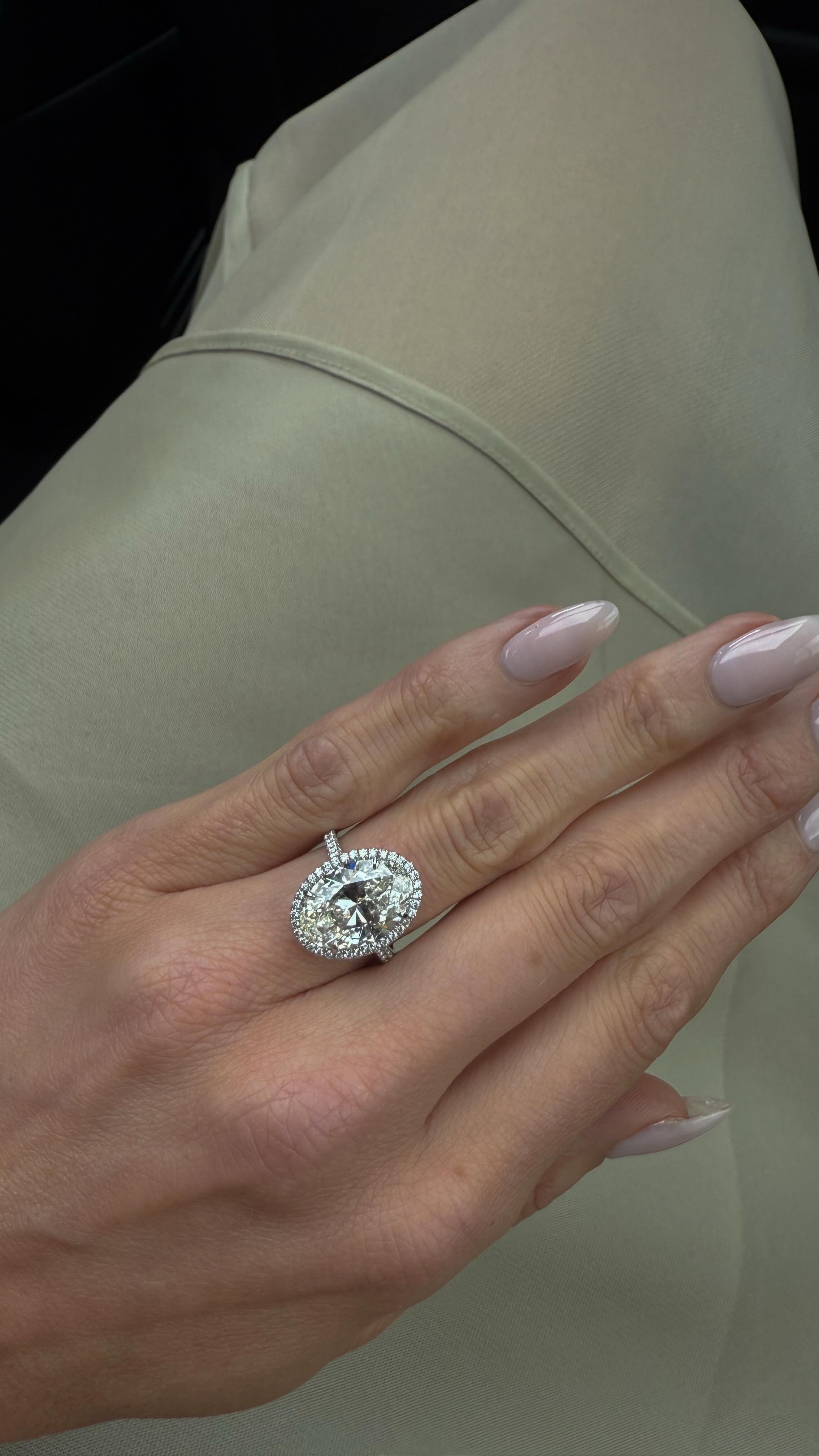 A close up picture of Elsa Hosk&#039;s oval engagement ring, featuring her milky pink manicure