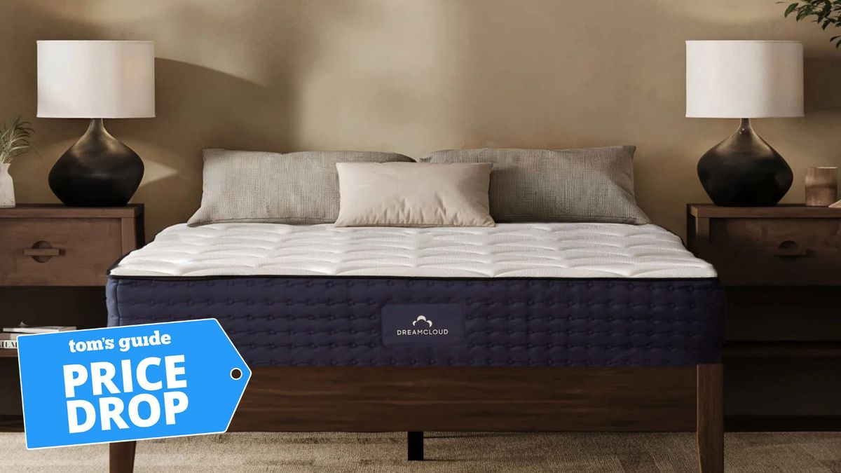 The dreamcloud mattress on a bed frame in a spacious bedroom