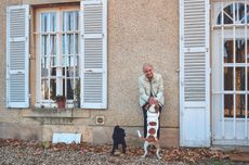 Woman with two dogs outside a house