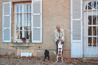 Woman with two dogs outside a house