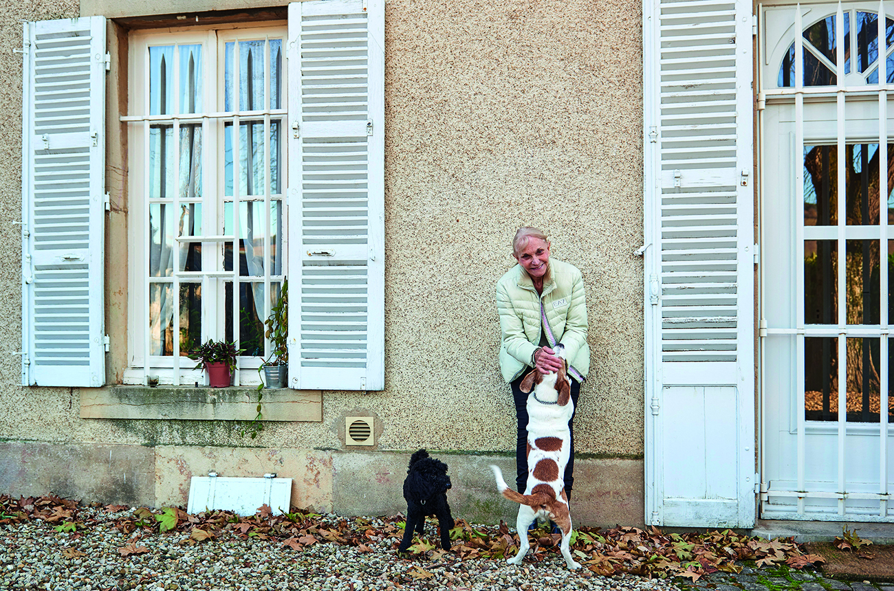 Woman with two dogs outside a house