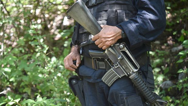 State police officer stands guard near a mass grave that was found in Iguala, Guerrero state, Mexico