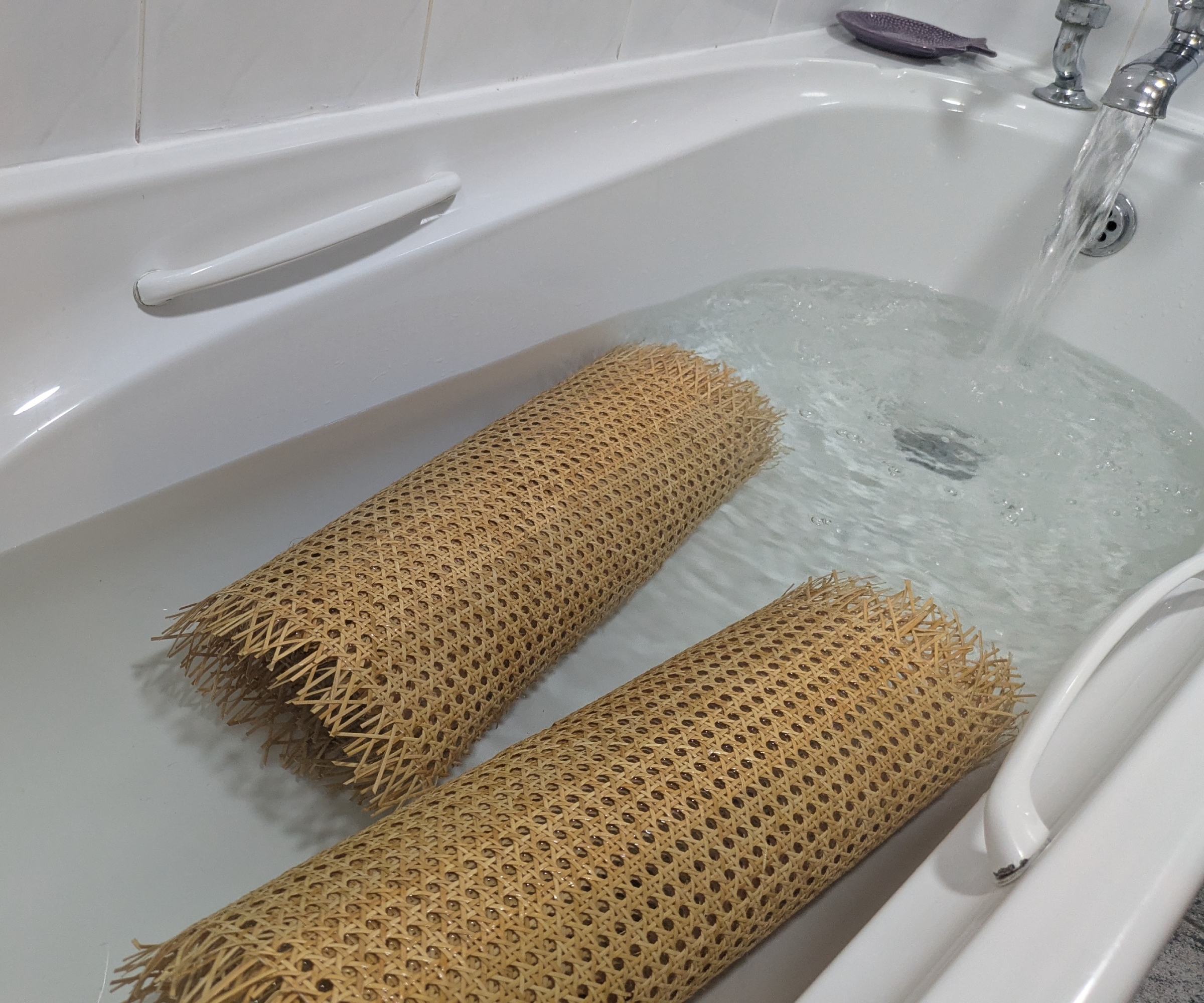 Rolls of cane webbing soaking in a bath