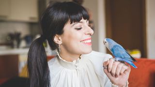 Woman smiles at pet bird
