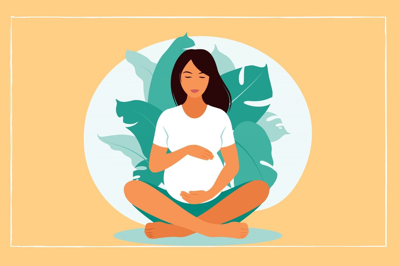 pregnant woman sat crossed leg on an orange background