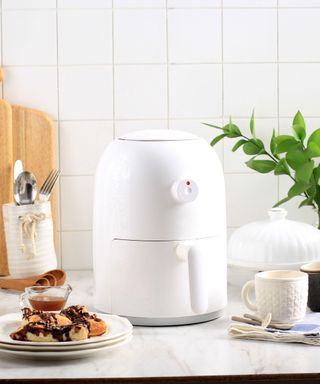 Air fryer in a white tiled kitchen