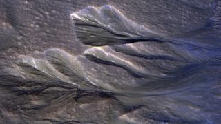 A satellite photo of gullies on Mars with ice around their edge