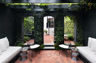 vine-covered brick wall in backyard by Evelyn Pierce