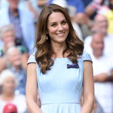 Kate Middleton wearing a blue dress and smiling