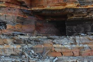 a brown and grey multi-layered jagged rock face