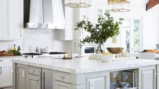 white kitchen with island and hood