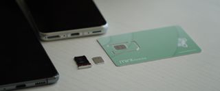 Mint Mobile SIM card near a phone SIM tray, ultra-wide header crop