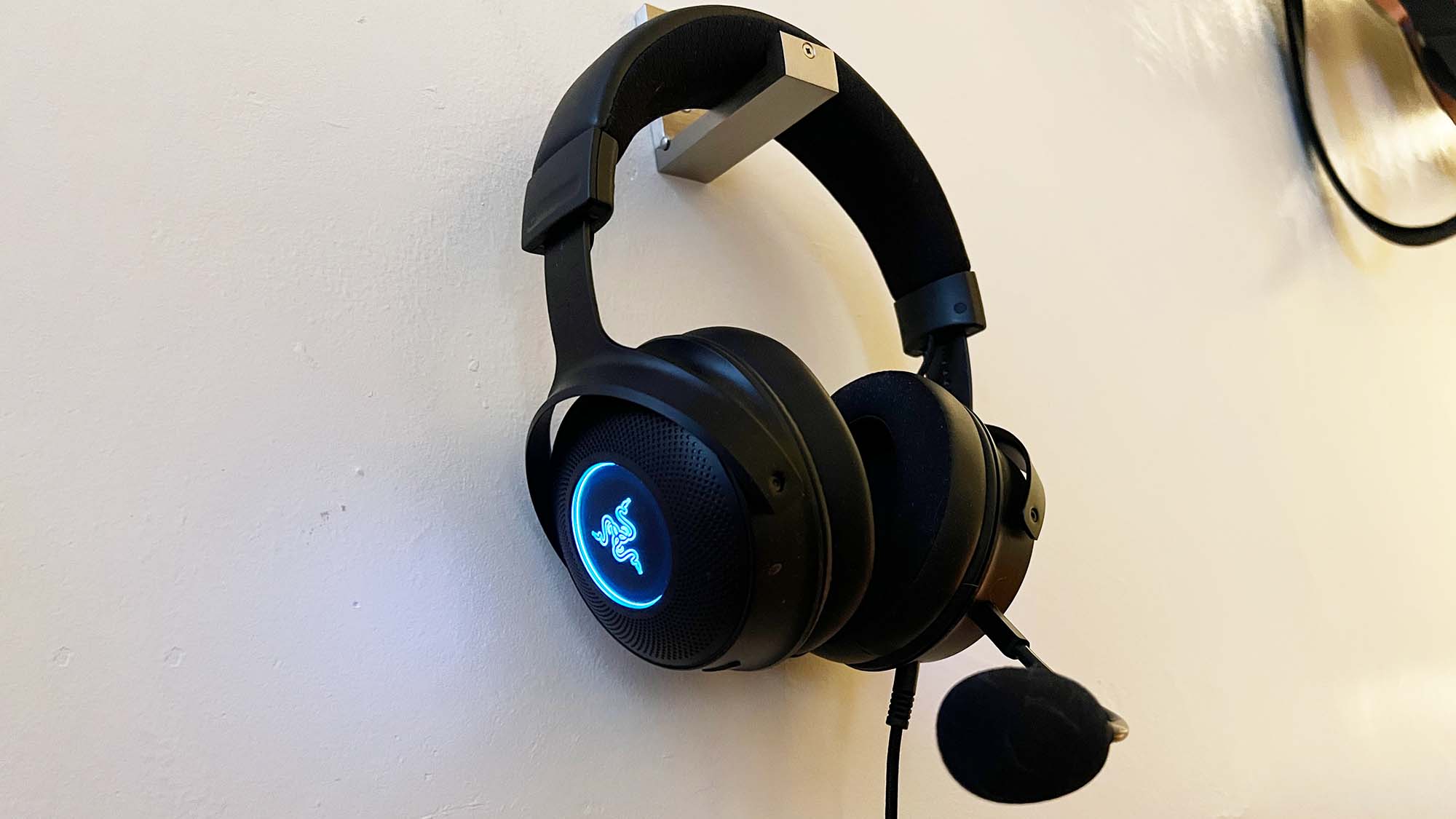 Gaming-headsettet Razer Kraken V3 HyperSense opphengt på en vegg.