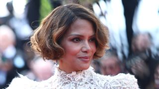 Halle Berry in creamy lace dress during her final night at Cannes 2025, with short hair curled around her ears.