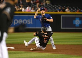 Corey Seager #5 of the Texas Rangers turns a double play on a ground ball hit by Jace Peterson #6 of the Arizona Diamondbacks as Alek Thomas #5 is forced out at second base during the second inning at Chase Field on August 22, 2023
