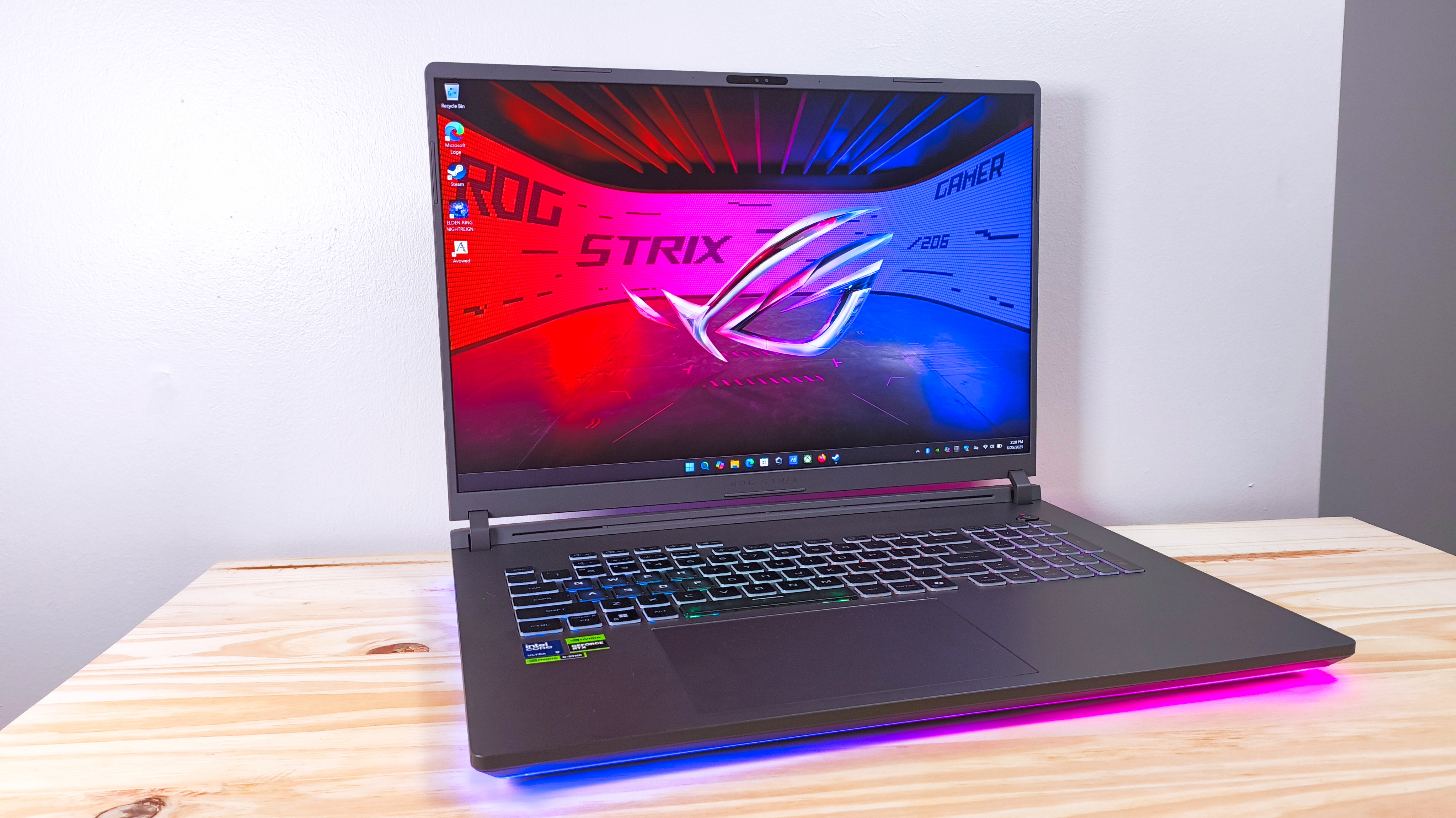 The Asus ROG Strix G18 with lid open on a wood table