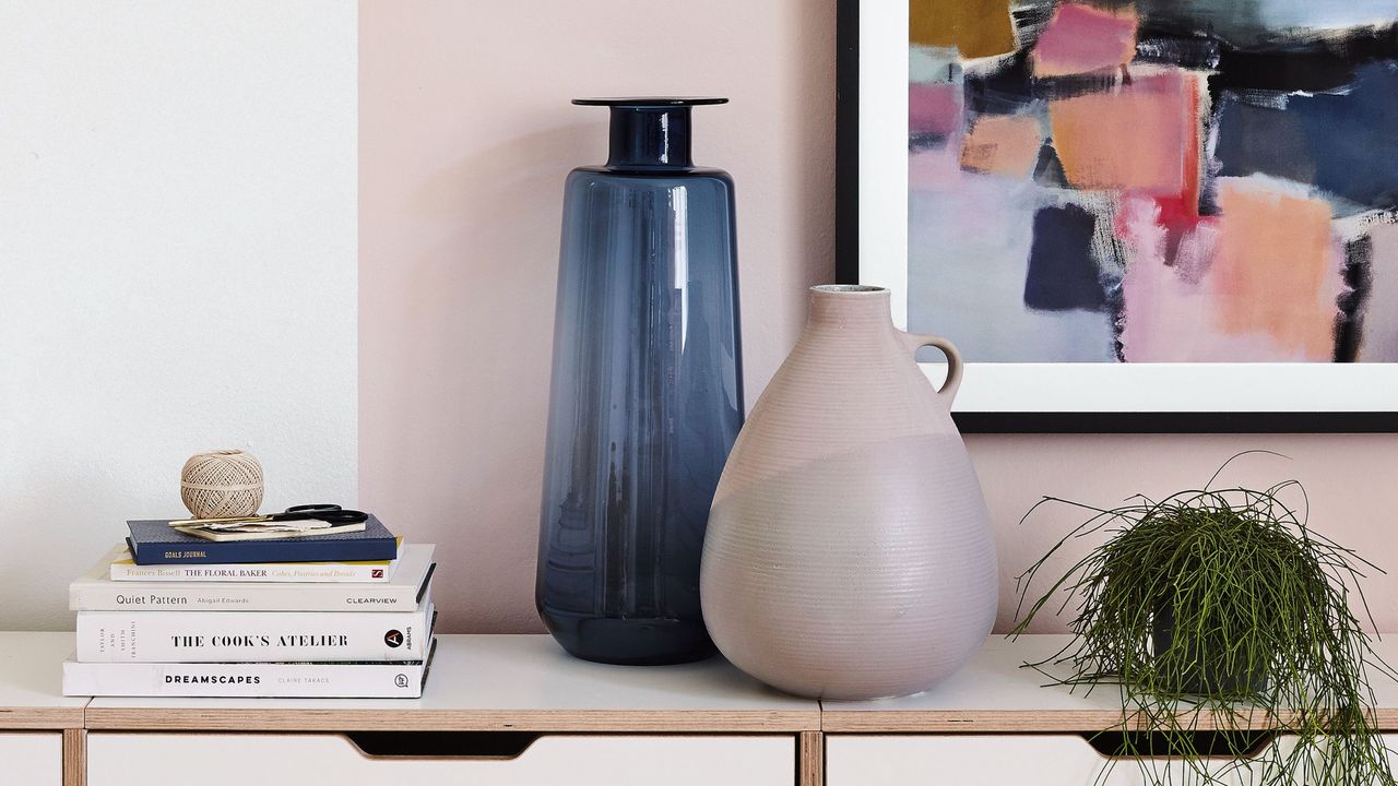 Decorative vase, books, and plant displayed on top of shelving