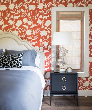 Orange bedroom with trellis wallpaper and blue bed linen
