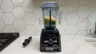 The Vitamix A3500 filled with pineapple and spinach on a kitchen countertop