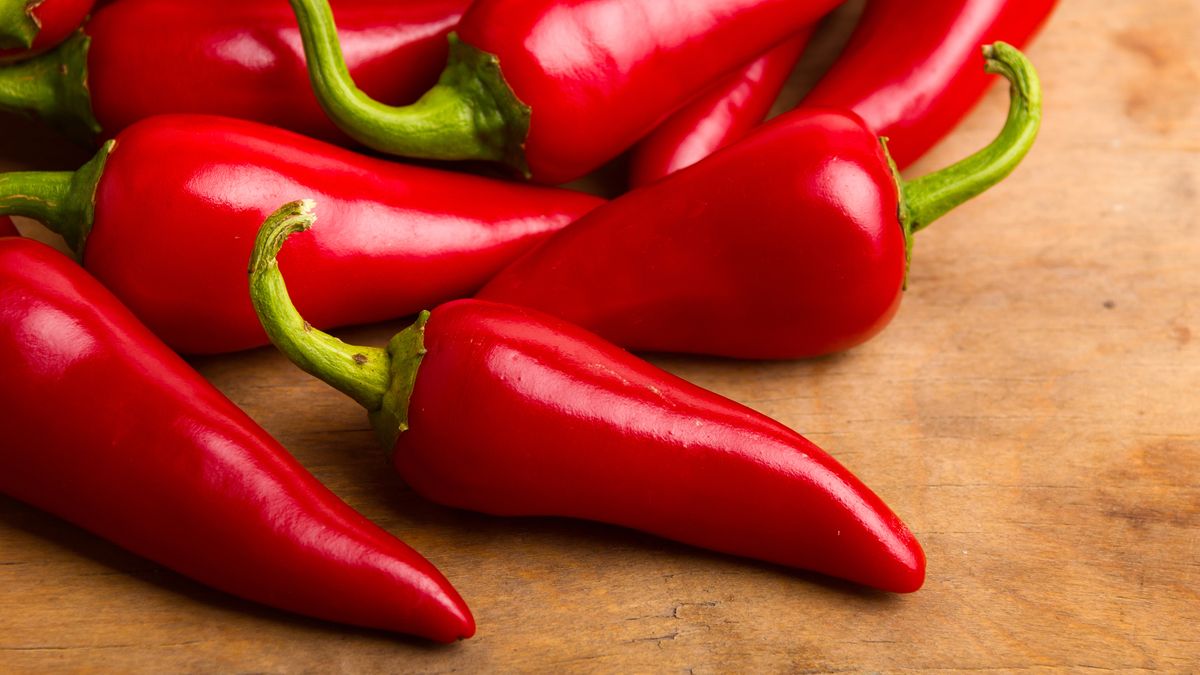 A pile of red chilli peppers on a wooden board