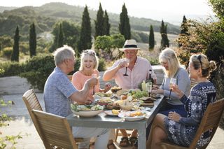 Five friends dining outside in an Italian villa