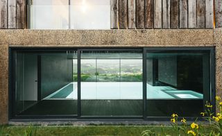 The central garden descends to give way to an indoor, near-infinity swimming pool that visually connects the garden to the views beyond
