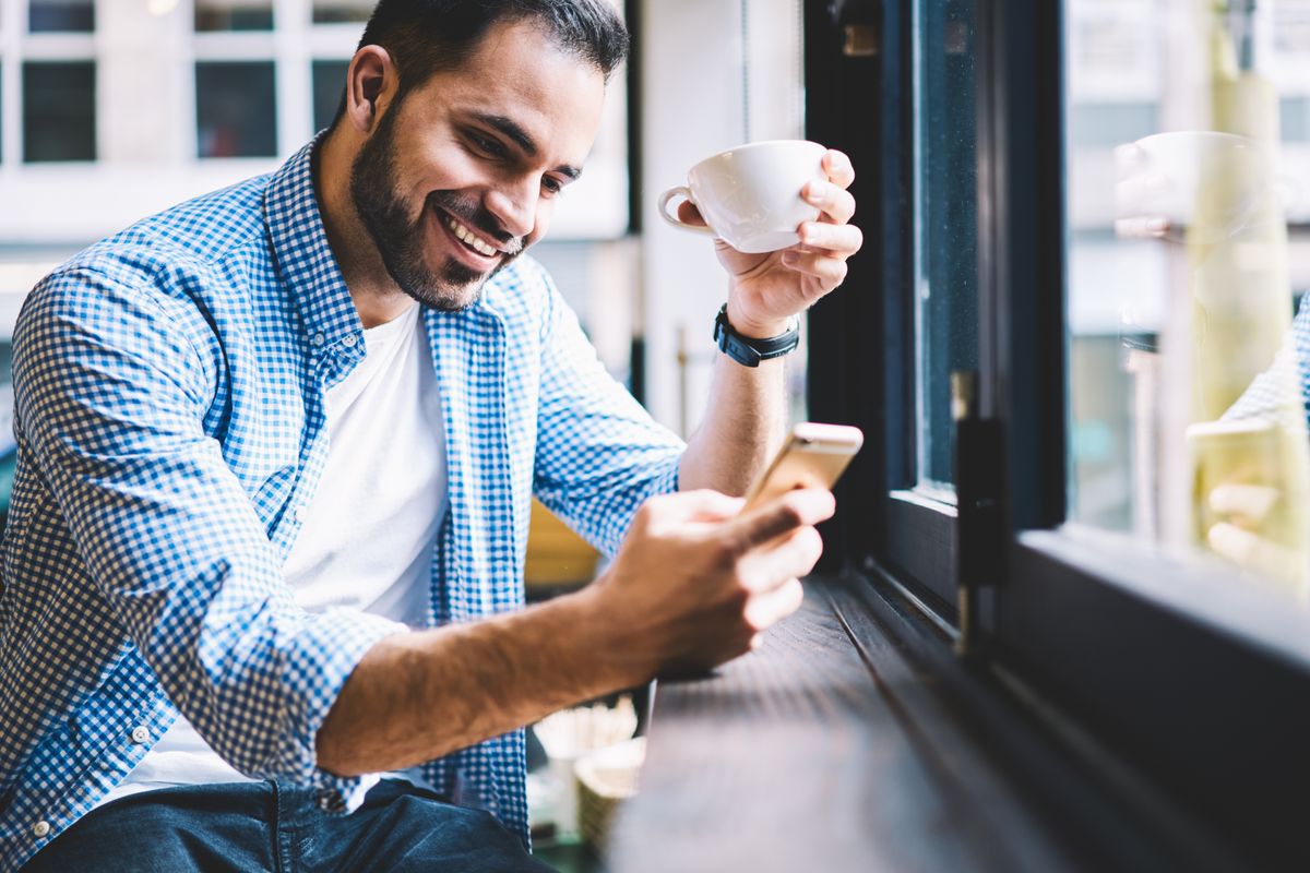 Man receiving text messages in a coffee shop