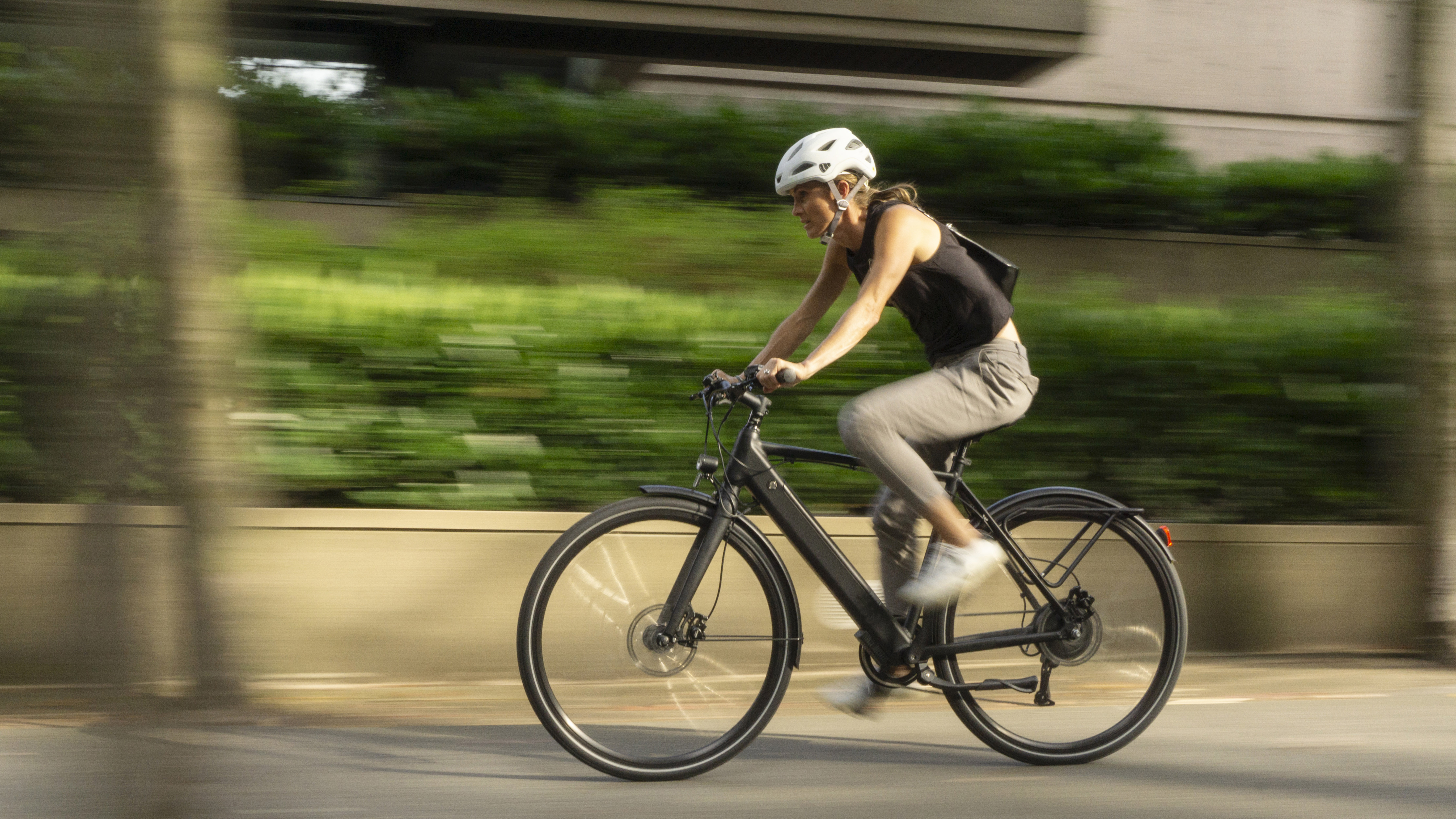 a female rider, riding an electric bike passing by in a blur of speed