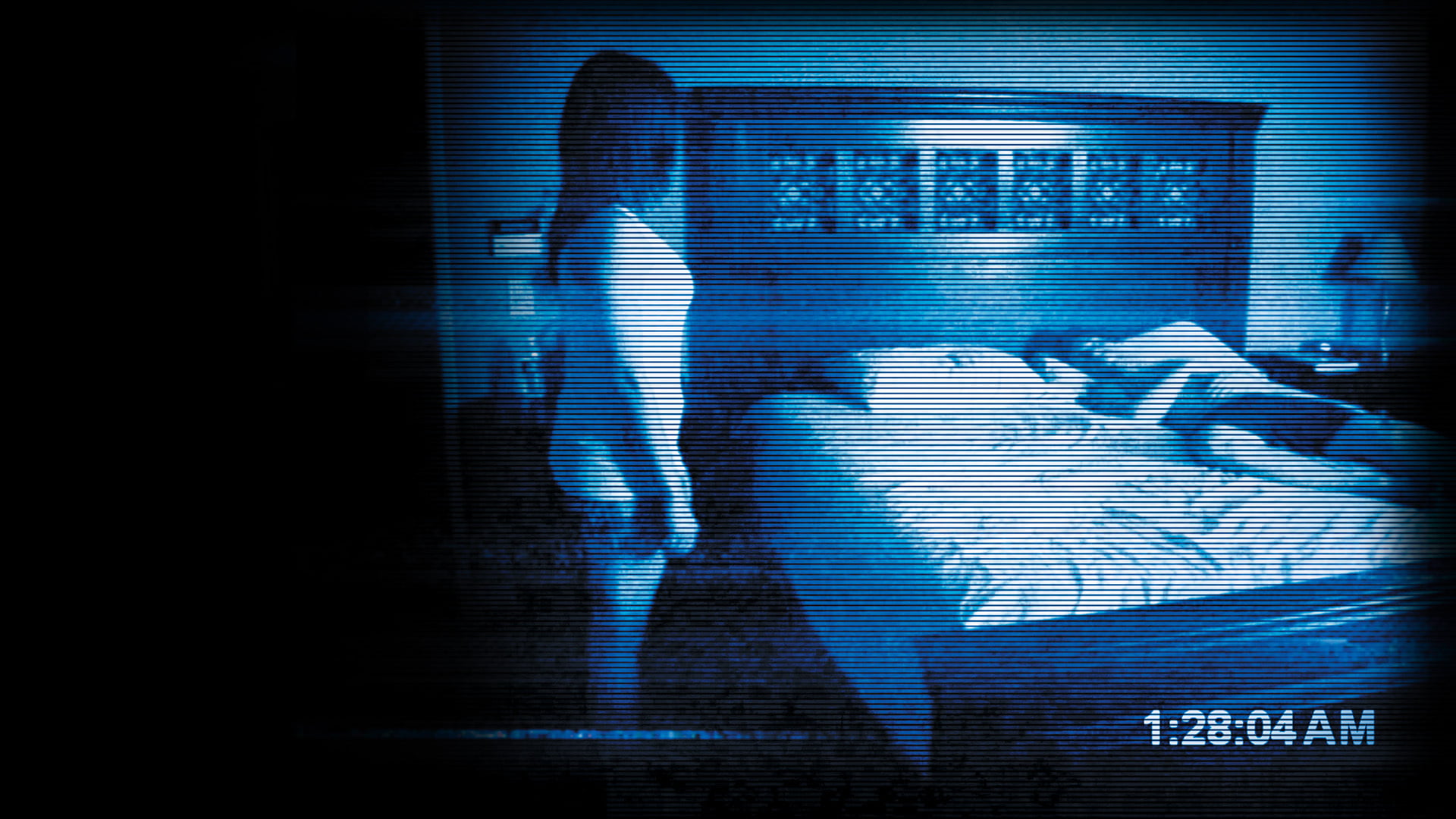 A woman stands over a man asleep in his bed in Paranormal Activity