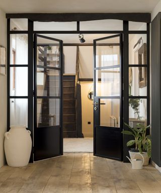 A pair of glazed metal doors surrounded by glazed panels in a hallway