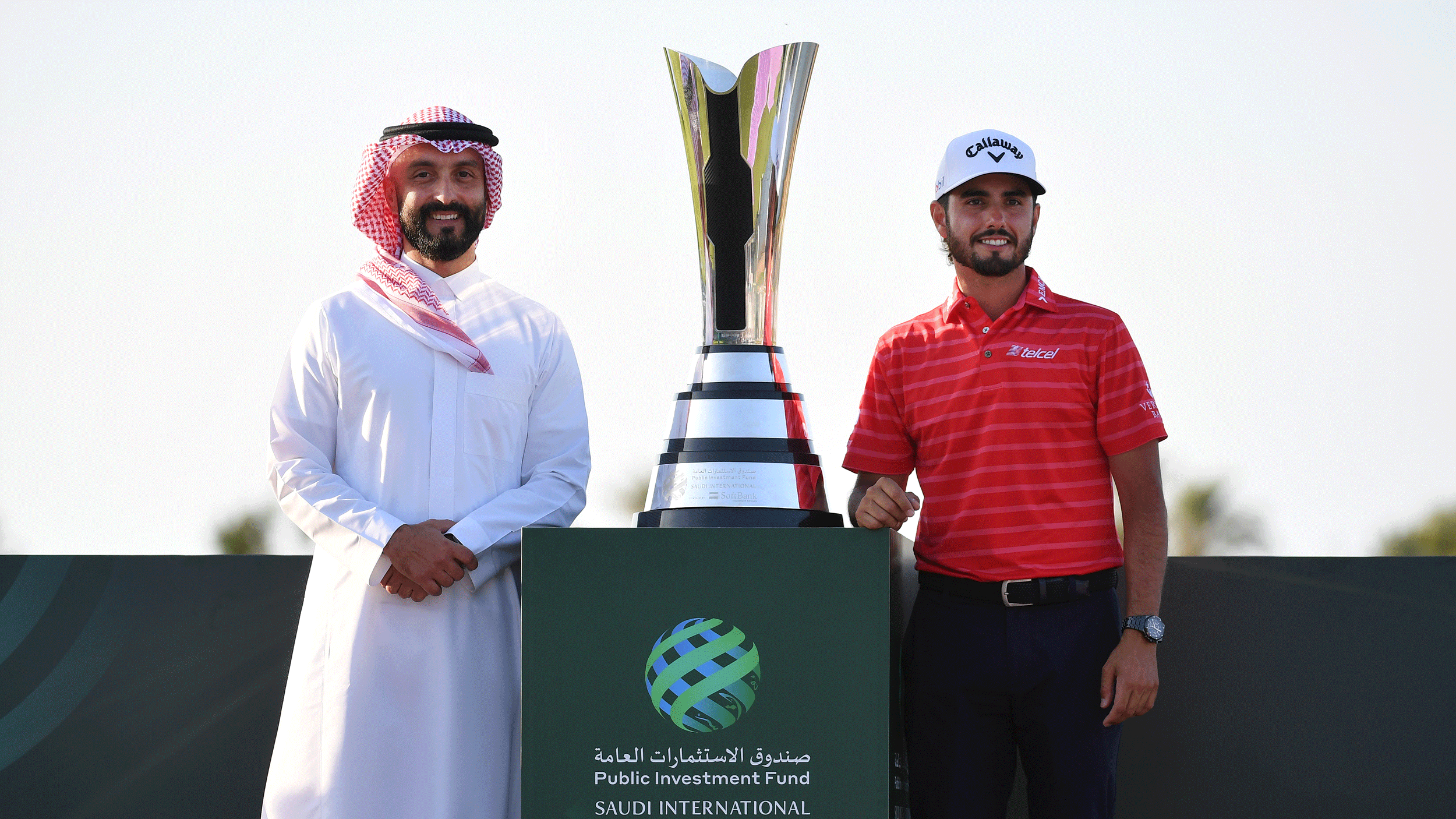 Noah Alireza (left) and Abraham Ancer stand either side of the PIF Saudi International trophy in 2024